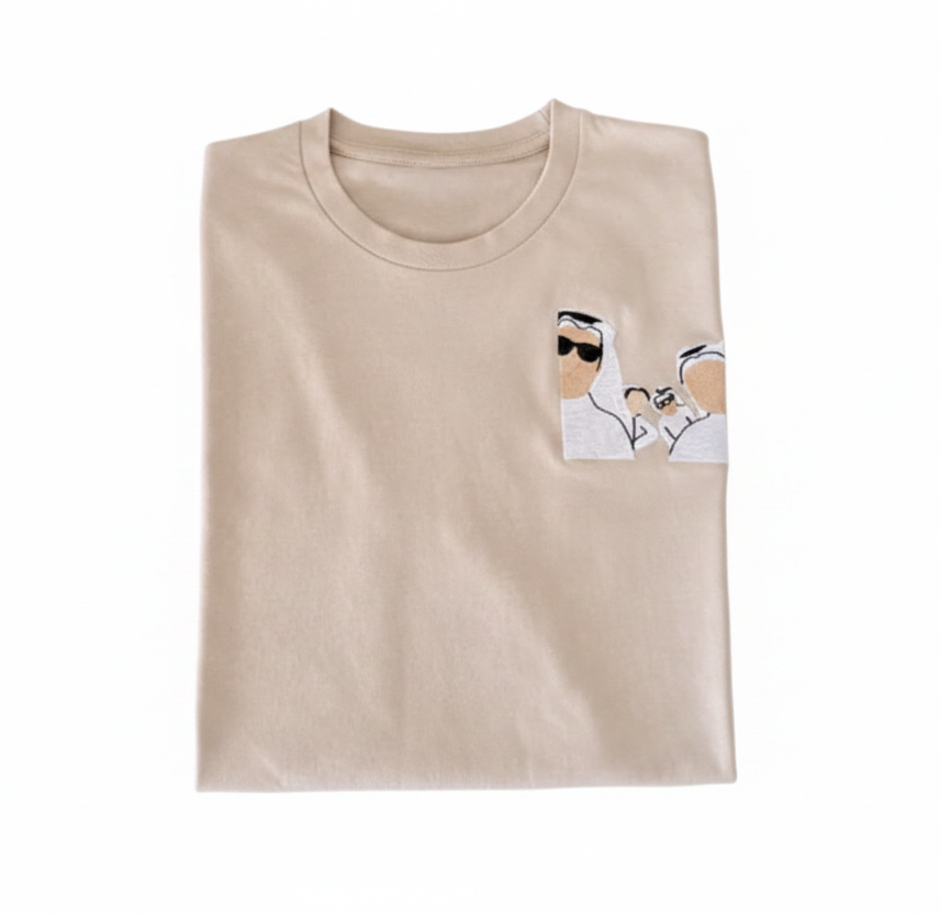 Folded beige t-shirt with a small graphic on a white background