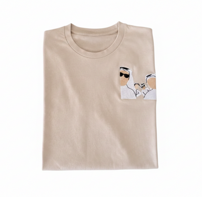 Folded beige t-shirt with a small graphic on a white background
